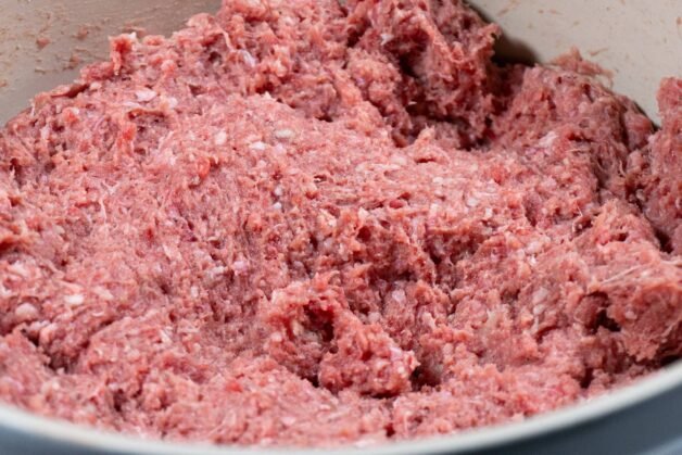 A close-up of the seasoned ground meat mixture for cevapi preparation.