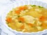 Bowl of Chicken Semolina Dumpling Soup with carrots, cauliflower, and parsley garnish.