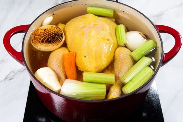 Chicken and vegetables in a pot with water for chicken stock.