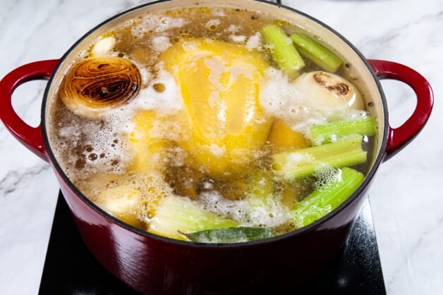 Chicken and vegetables simmering in water for stock.