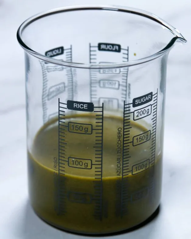 Freshly prepared basil dressing in a measuring cup.