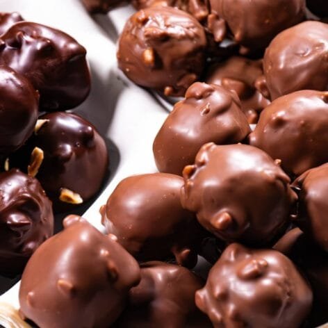 A white dish filled with Nutella Crunch Bites coated in dark and milk chocolate.