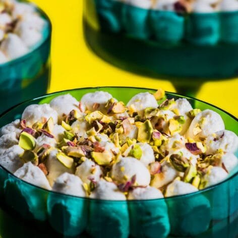 Pistachio Delight Dessert Cups with Chocolate Base and Cream Cheese Topping, garnished with chopped pistachios in an elegant emerald-green glass.