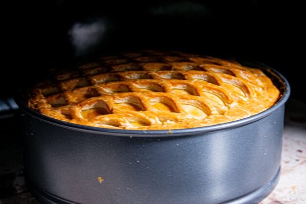 Chicken and mushroom pie baking in the oven with a golden lattice crust.