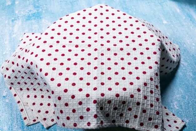 A bowl covered with a dotted kitchen towel, allowing the dough to rest.