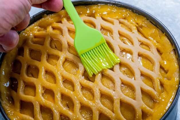 Applying egg wash to the lattice crust of the creamy chicken and mushroom pie.