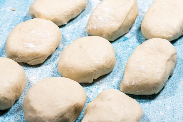 Individual portions of dough on a floured surface, ready for shaping.