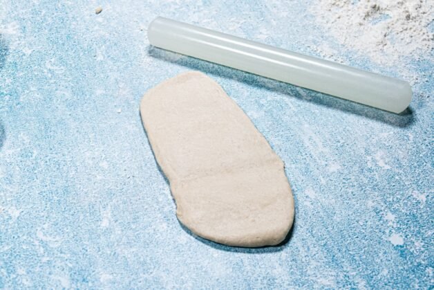 A portion of dough rolled into a rectangle, ready for folding.