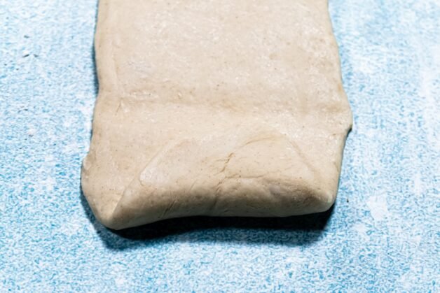 Bottom edge of the dough folded upward.
