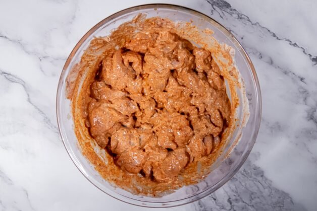 Chicken pieces marinating in a spiced yogurt mixture, ensuring tenderness and deep flavor for Butter Chicken.