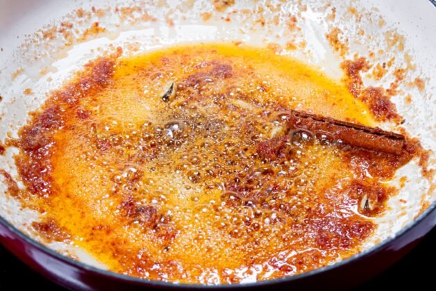 Sizzling tomato paste cooking with butter, cinnamon, and spices, deepening the flavor for Butter Chicken sauce.
