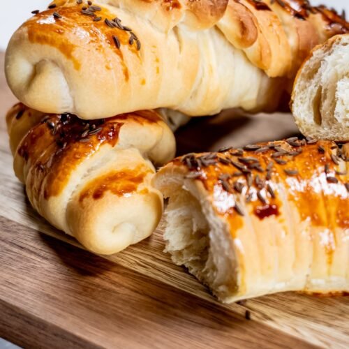 Golden crescent rolls with caraway seeds on a wooden board